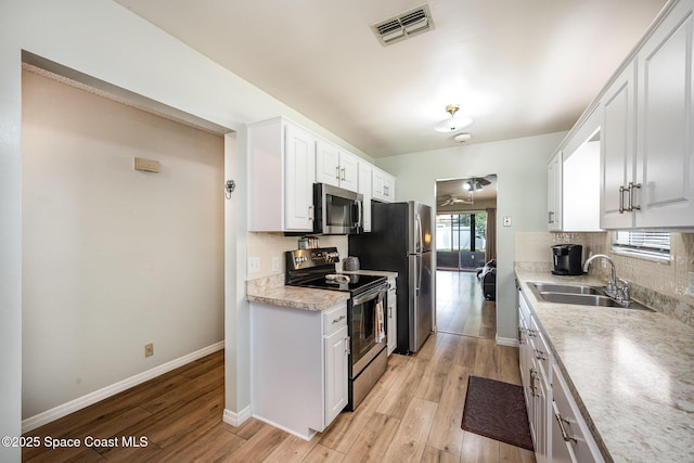 kitchen with a sink, visible vents, backsplash, and appliances with stainless steel finishes