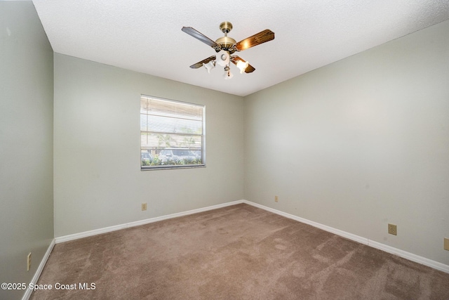 carpeted empty room featuring baseboards and ceiling fan