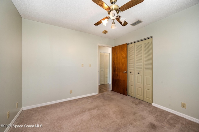 unfurnished bedroom featuring visible vents, baseboards, carpet, and a closet