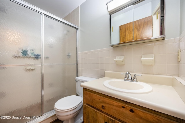 bathroom with toilet, tile walls, and a shower stall