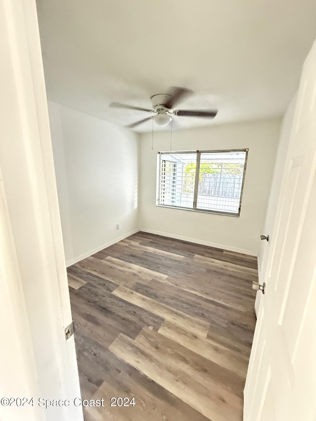 unfurnished room with ceiling fan and dark wood-type flooring