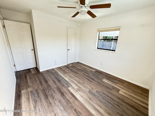 unfurnished bedroom with ceiling fan and dark hardwood / wood-style floors