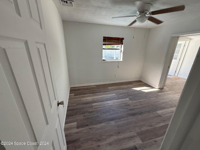 unfurnished room with dark hardwood / wood-style floors, a textured ceiling, and ceiling fan