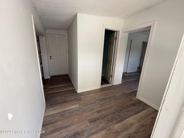 corridor with dark wood-type flooring and a textured ceiling