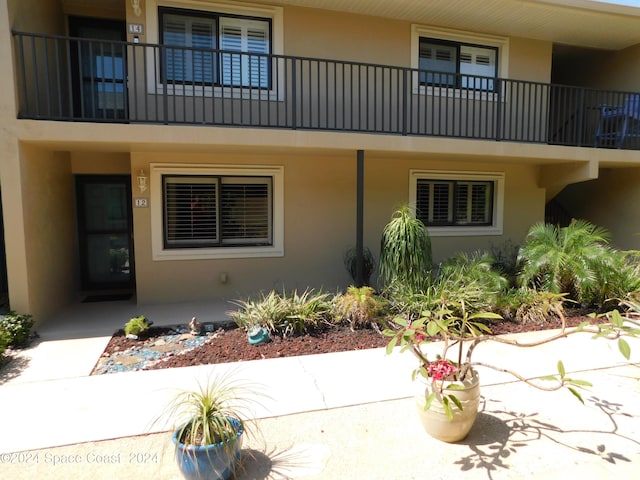 view of exterior entry featuring a balcony