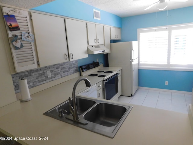 kitchen featuring a textured ceiling, sink, white cabinets, decorative backsplash, and white appliances