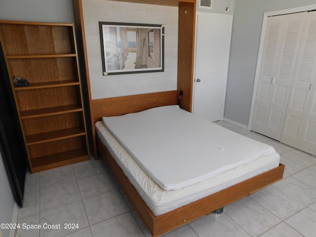 bedroom with light tile patterned floors and a closet