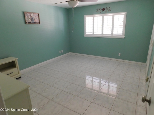 tiled spare room with ceiling fan