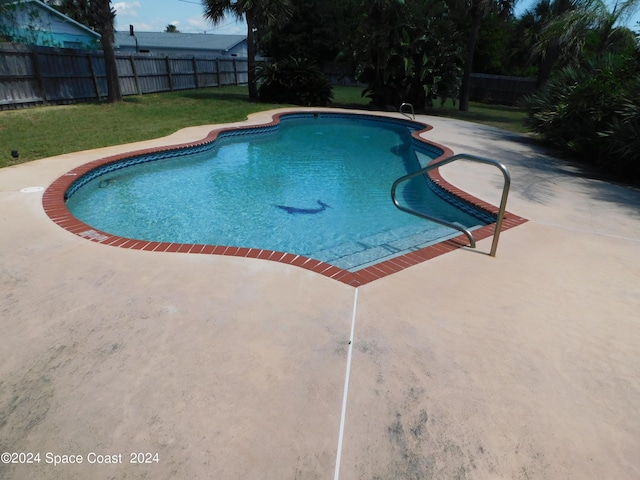 view of swimming pool with a fenced backyard, a fenced in pool, a patio, and a lawn