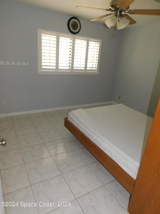 unfurnished bedroom with ceiling fan and light tile patterned floors