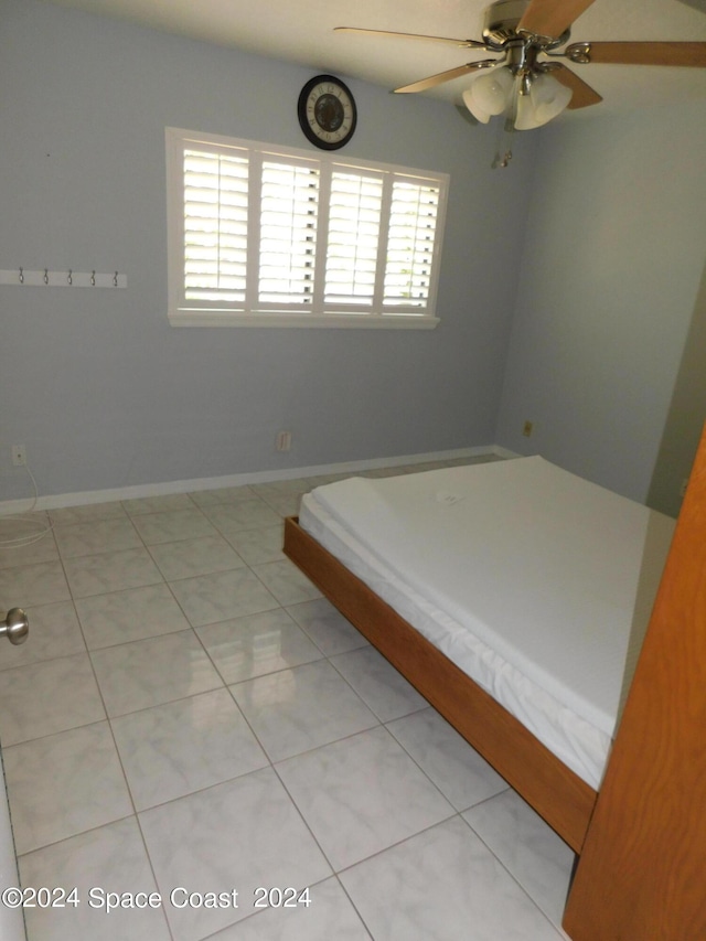 unfurnished bedroom with baseboards, ceiling fan, and light tile patterned flooring