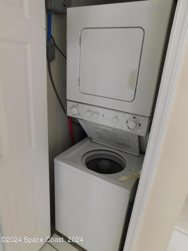 clothes washing area with stacked washer and clothes dryer