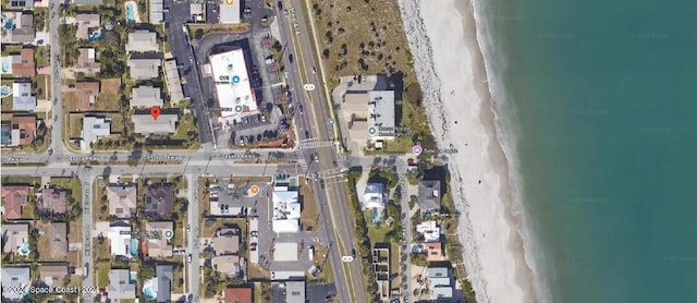 drone / aerial view with a beach view and a water view