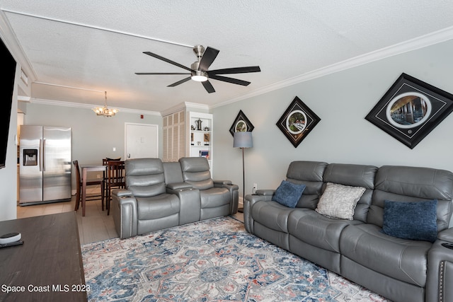 living room featuring ornamental molding, a textured ceiling, light wood-type flooring, and ceiling fan with notable chandelier