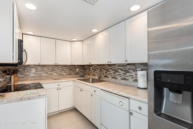 kitchen with white dishwasher, sink, stainless steel fridge with ice dispenser, light stone countertops, and white cabinets