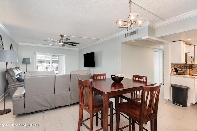 dining space featuring ornamental molding, a textured ceiling, ceiling fan with notable chandelier, and light tile patterned floors