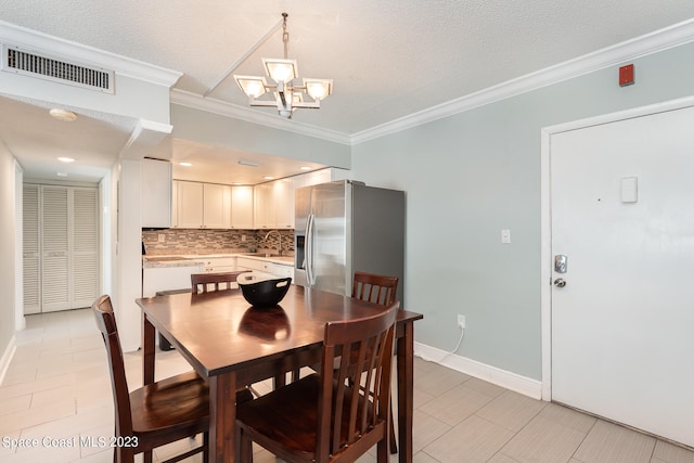 tiled dining area with crown molding, a textured ceiling, sink, and a notable chandelier