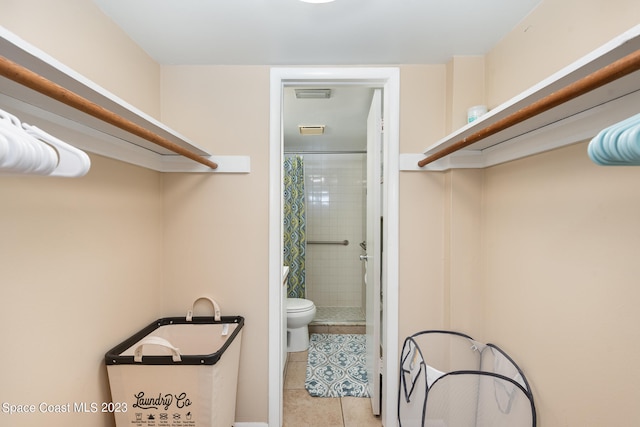 bathroom with toilet, tile patterned flooring, and a shower with shower curtain