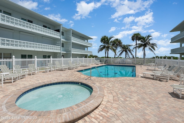 view of pool with a hot tub and a patio area