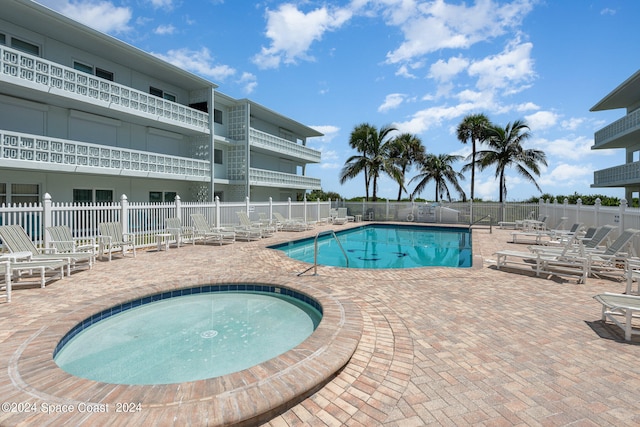 view of pool featuring a hot tub and a patio area