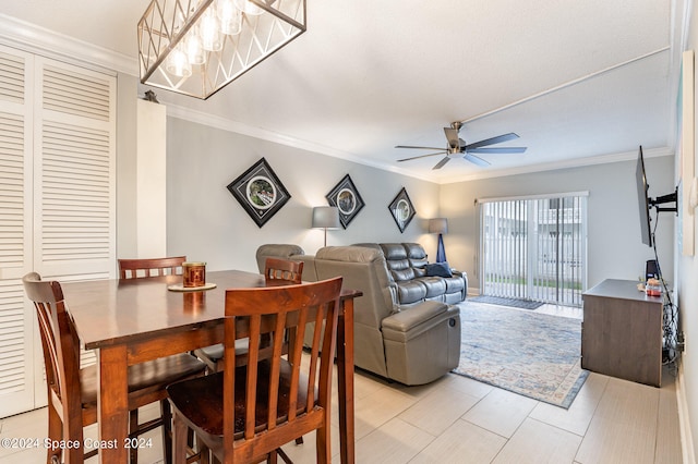 dining room with crown molding and ceiling fan with notable chandelier