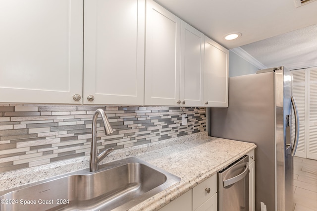 kitchen with light stone countertops, sink, white cabinets, and backsplash