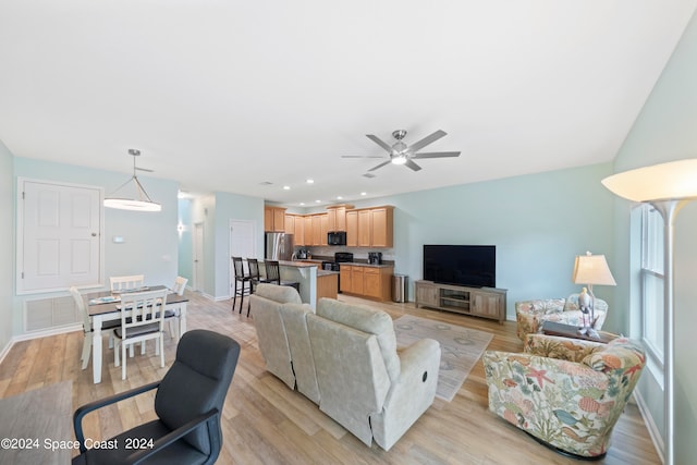 living room with ceiling fan and light hardwood / wood-style flooring