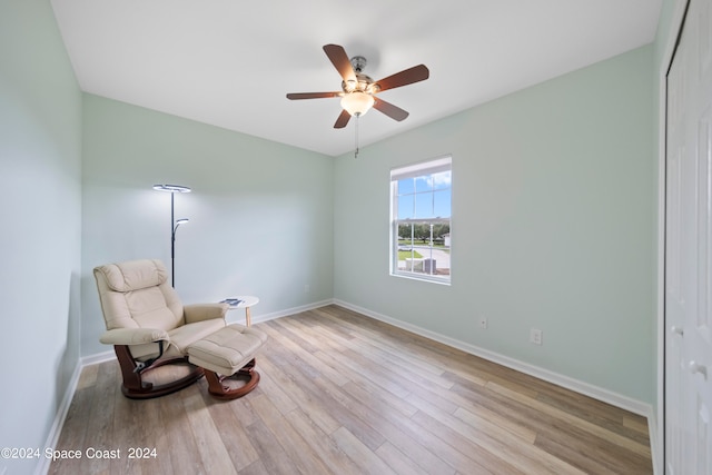 sitting room with light wood-type flooring and ceiling fan