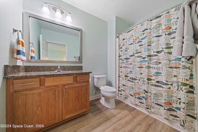 bathroom with a shower with shower curtain, wood-type flooring, vanity, and toilet