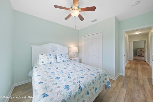 bedroom with ceiling fan, light hardwood / wood-style flooring, and a closet