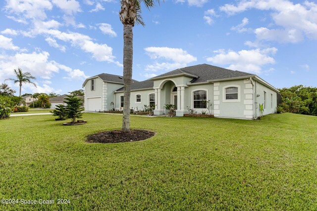 929 Hialeah St, Rockledge, FL 32955 - view of front facade with a garage, roof with shingles, stucco siding, and a front lawn
