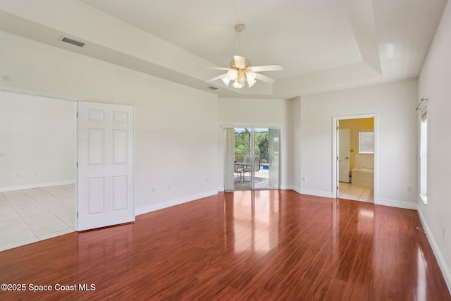 929 Hialeah St, Rockledge, FL 32955 - unfurnished room with visible vents, baseboards, a ceiling fan, a tray ceiling, and wood finished floors