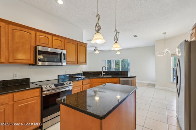 929 Hialeah St, Rockledge, FL 32955 - kitchen featuring a kitchen island, visible vents, brown cabinets, stainless steel appliances, and a sink