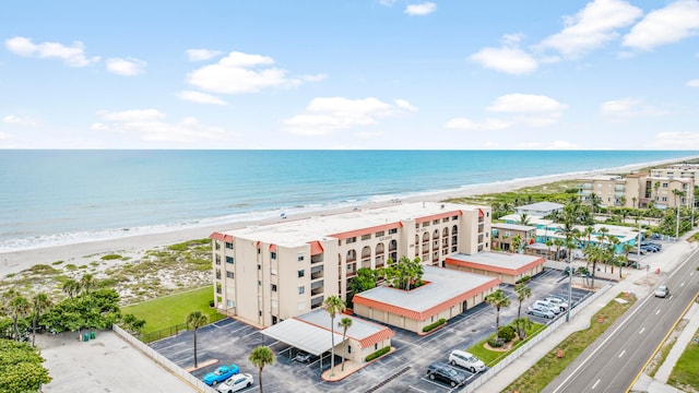 drone / aerial view featuring a water view and a view of the beach