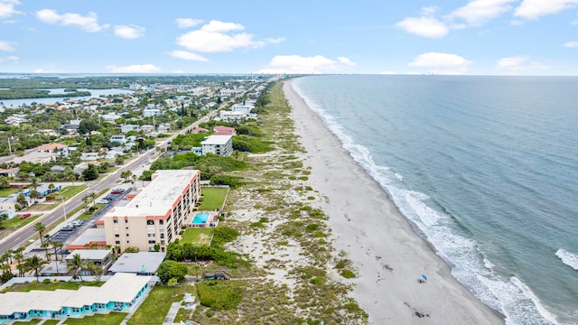 birds eye view of property with a water view and a beach view