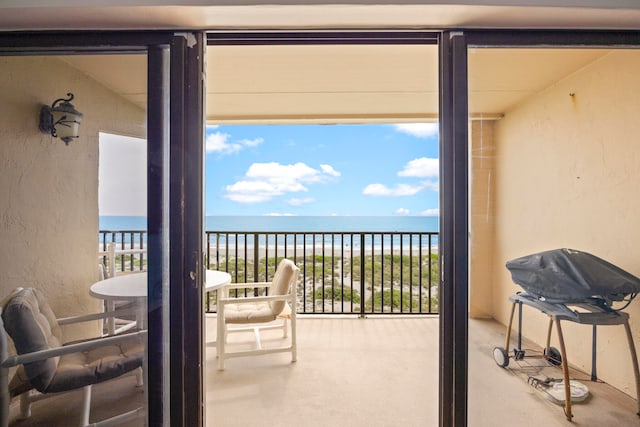 balcony with a beach view, grilling area, and a water view