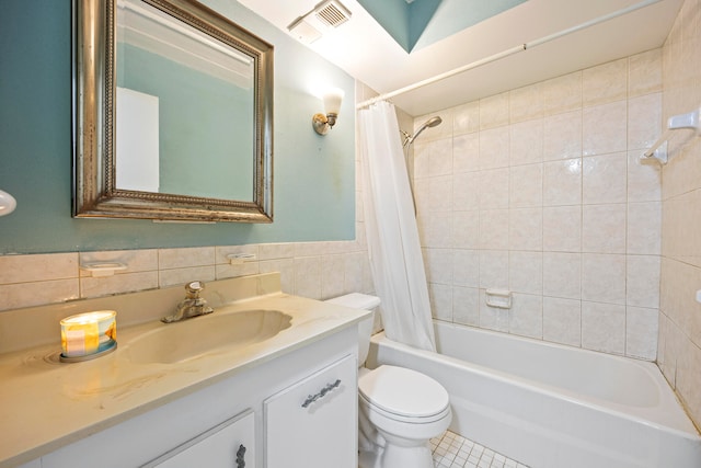 full bathroom featuring shower / bathtub combination with curtain, tile walls, vanity, and toilet