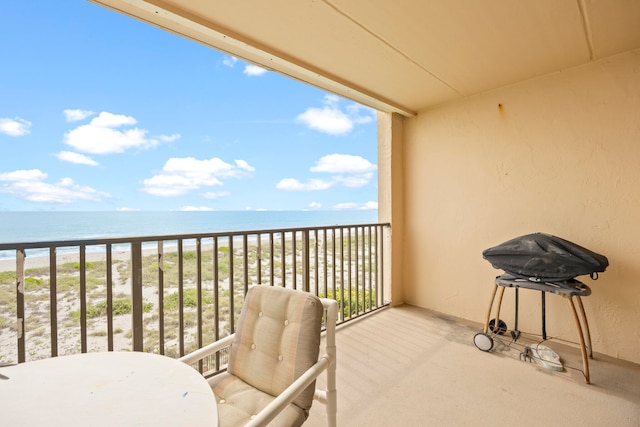 balcony with a water view and a view of the beach