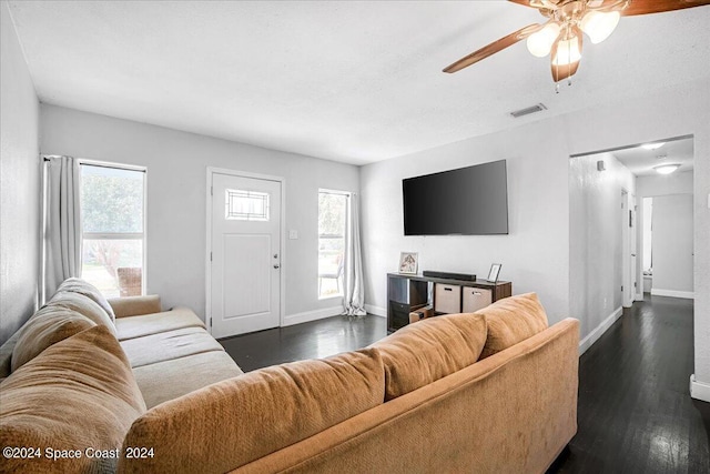 living room featuring ceiling fan and dark wood-type flooring