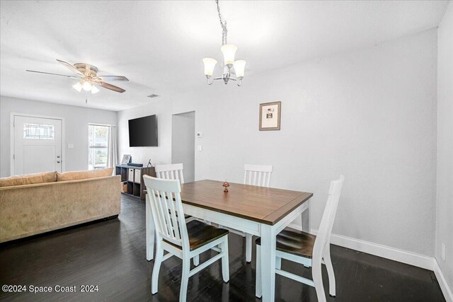 dining room featuring ceiling fan with notable chandelier and dark hardwood / wood-style floors