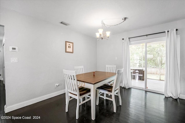 dining room with dark wood-type flooring and a notable chandelier