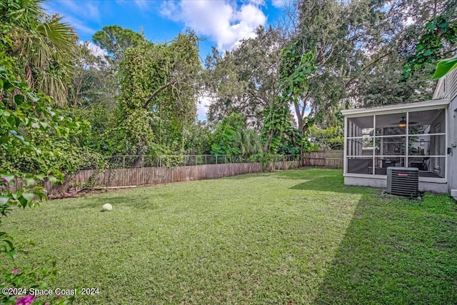 view of yard with a sunroom and central air condition unit