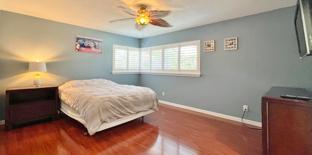 bedroom with ceiling fan and dark hardwood / wood-style flooring