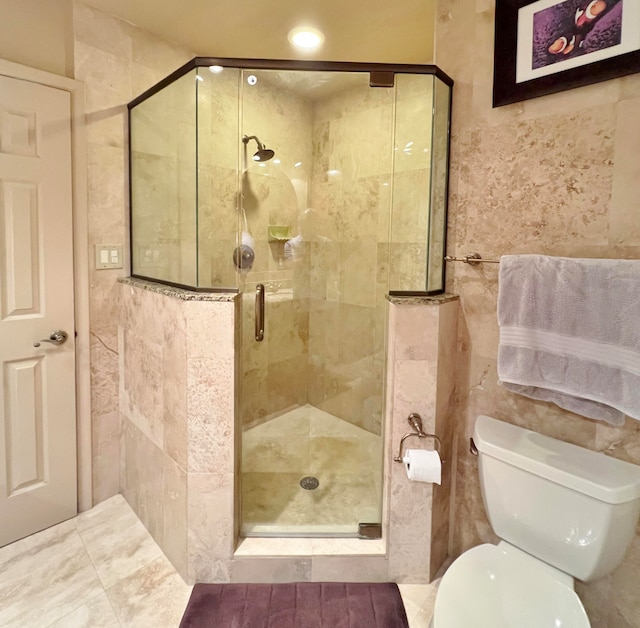 bathroom featuring tile walls, toilet, and a shower with door