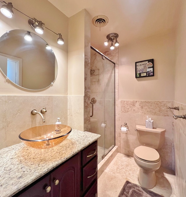 bathroom with tile walls, vanity, and toilet