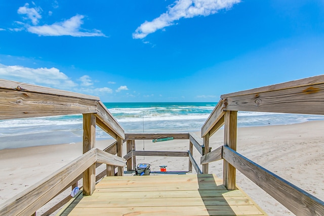 view of home's community with a water view and a beach view