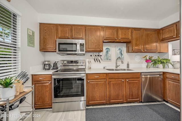 kitchen featuring appliances with stainless steel finishes, sink, and decorative backsplash