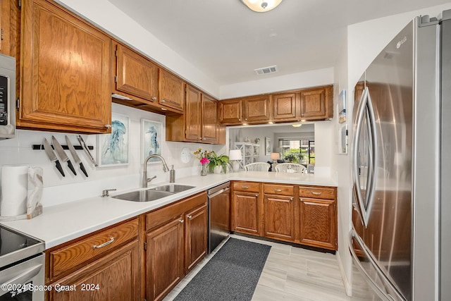 kitchen with light hardwood / wood-style floors, appliances with stainless steel finishes, backsplash, and sink