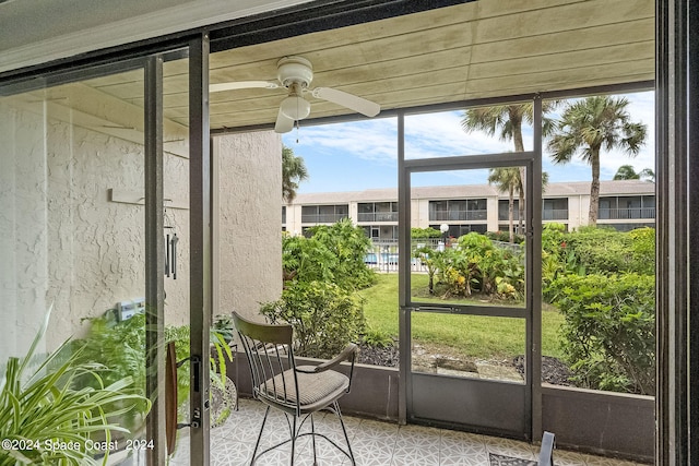 unfurnished sunroom featuring ceiling fan