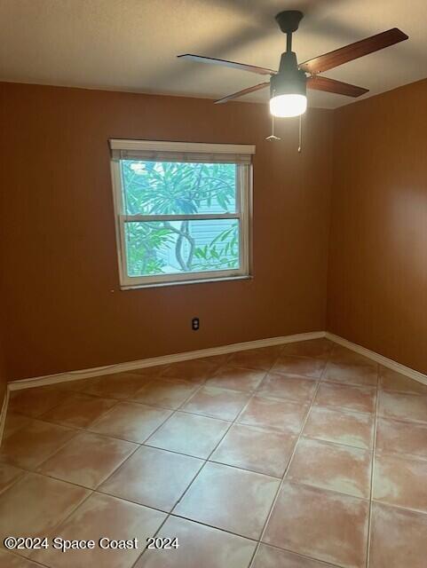 tiled empty room with ceiling fan